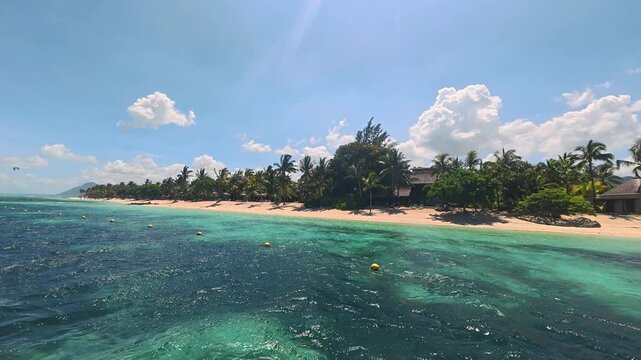 Tropical beach resort with palm trees and turquoise ocean water in Mauritius