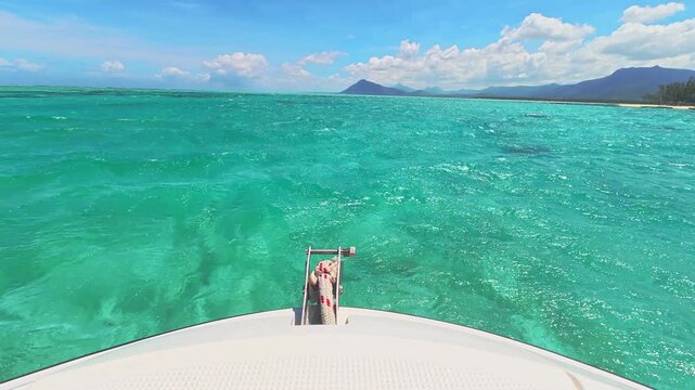 First person view from a speedboat cruising over turquoise tropical ocean water near Mauritius