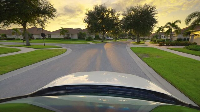 Driving a car from personal perspective on American street in Florida residential area.