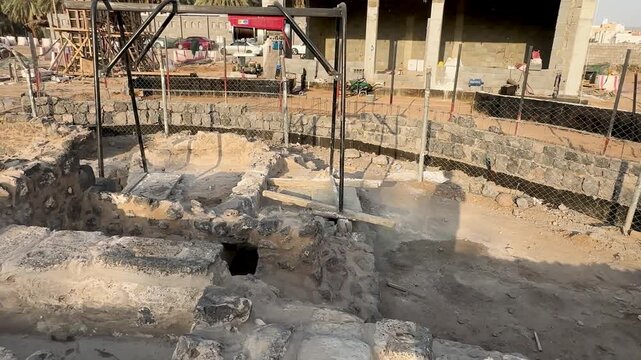 Preservation work on ancient stone foundations at an active archaeological dig site.