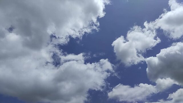Un cielo de azul con varias nubes de color blanco y gris con un movimiento lento