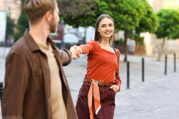 Fototapeta premium Happy couple walking together on city street, selective focus