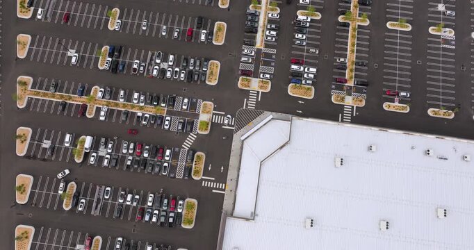 Large outdoor parking lot full of cars at shopping mall retail center, showing commercial success, consumer behavior and suburban development.