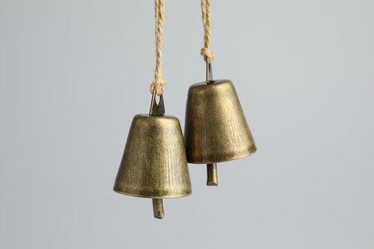 Beautiful metal bells on light grey background, closeup