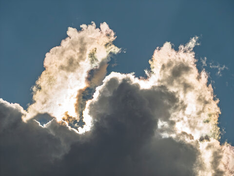 Iridescent clouds in blue sky with bright sun light