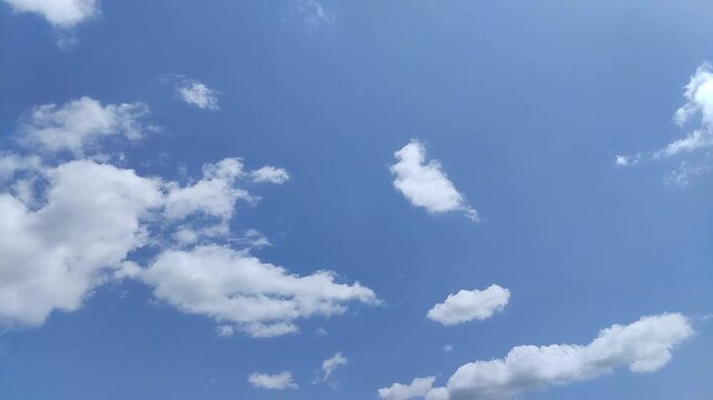 Un cielo de azul con varias nubes de color blanco y gris con un movimiento lento