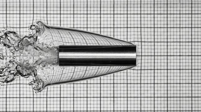 Vista macro cient&iacute;fica de un cilindro met&aacute;lico desplaz&aacute;ndose bajo el agua
