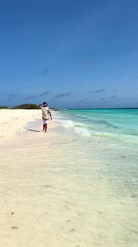 Carefree man walking on tropical Caribbean beach in Klein Cura&ccedil;ao