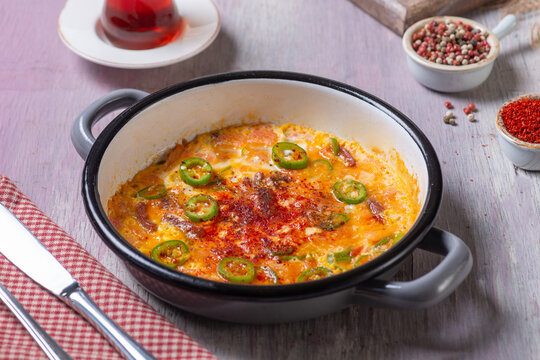 Close-Up View of Turkish Menemen Scrambled Eggs with Pastirma and Peppers in Enamel Pan
