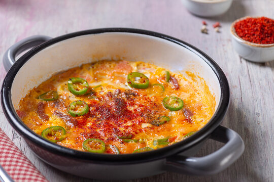Close-Up View of Turkish Menemen Scrambled Eggs with Pastirma and Peppers in Enamel Pan