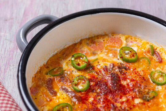 Close-Up View of Turkish Menemen Scrambled Eggs with Pastirma and Peppers in Enamel Pan
