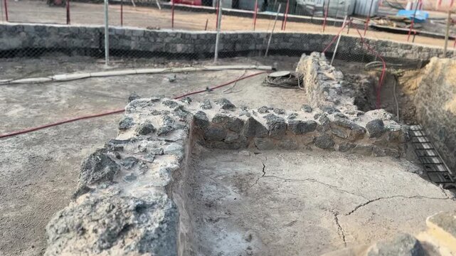 Ongoing archaeological excavation and restoration of ancient stone ruins and foundations.