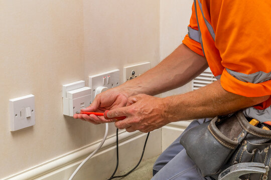 Electrician fitting UK master telephone socket faceplate in residential property