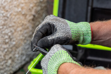 Telecoms engineer stripping outer sheath from fibre optic cable with buffer stripping tool © Tosh Lubek