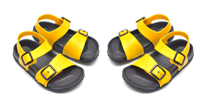 two pair of black and yellow shoes. Black and yellow  children's sandals made of rubber isolated on white background. Yellow flip-flops with black accents on the sole, isolated against.