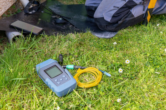 Fibre optic power meter and yellow test cable on grass at residential FTTP installation