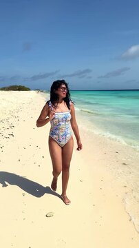 Woman walking on a tropical Caribbean beach in Klein Cura&ccedil;ao