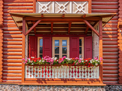 Flower Box Balcony With Red Shutters on Traditional Painted Wooden House Exterior