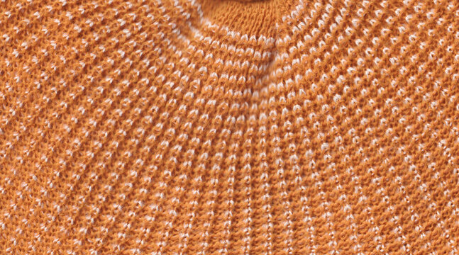Orange knitted wool fabric texture close up with detailed yarn pattern background