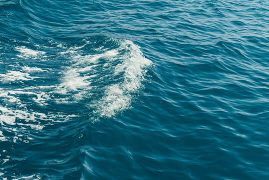 Blue sea water background texture with Gentle Water Movement. Blue ocean water surface with gentle waves, natural ripples, and soft sunlight reflections
