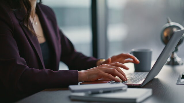 Closeup woman typing keyboard laptop at office. Manager focusing on online work