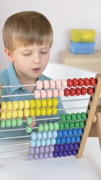 Close up of wooden abacus with colorful beads moving during counting exercise. Practical mathematics activity supporting STEM learning, logical thinking and early childhood education concept. 