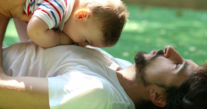 Candid authentic father and baby boy relationship lifting son