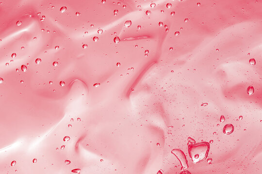 Pink transparent cosmetic product as background, closeup