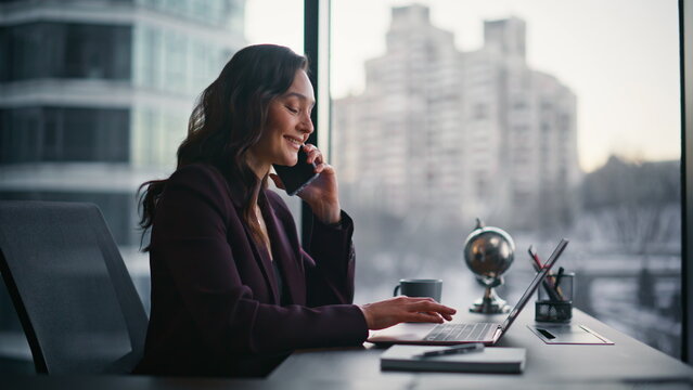 Positive consultant talking mobile phone conversation in modern office closeup