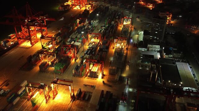 Unloading large cargo containers seaport. Loading freight sea port. Top aerial drone view. Lot big boxes rows, ship delivery ocean harbor. Shipping night. Goods export import. Industrial Marine dock.