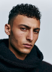 Obraz premium Young Curly Haired Man in Black Hoodie Portrait