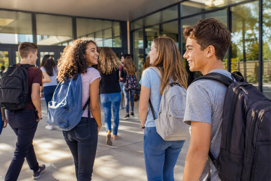 Diverse Group of Happy High School Students Walking and Talking Outside Modern School Building.