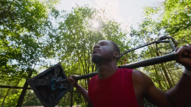 African American young adult man performing squats with makeshift barbell in outdoor gym, slow motion. Clip is ideal for fitness motivation, strength training, and lifestyle commercials