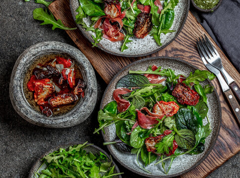 Salad with arugula, spinach, dried tomato and ham serrano paleta iberica. Low carbs keto recipe
