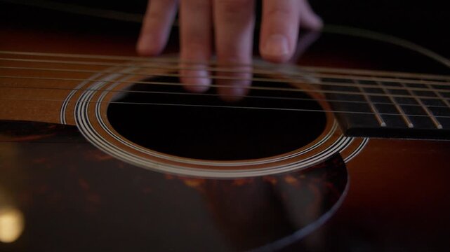 Luthier Reducing Tension on Acoustic Guitar Strings Before Restringing Shot with Cinema Camera