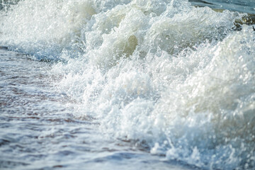 Naklejka premium Close up of powerful foamy sea wave crashing with white spray and water droplets.