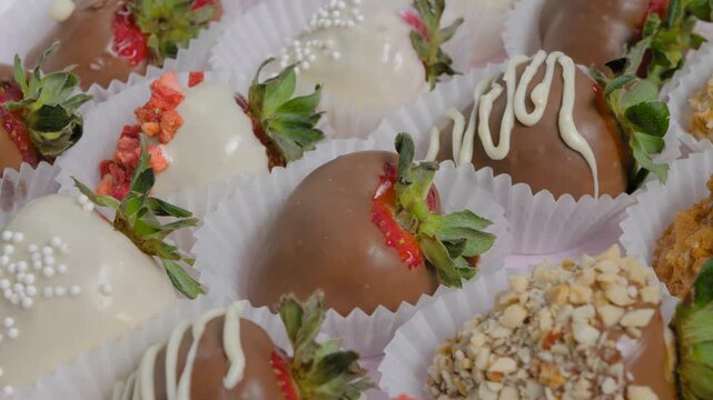 Set of different fresh chocolate covered strawberries on slow rotating surface - close up, macro, selective focus. Holiday, gift, confectionery, romantic and Valentine Day concept