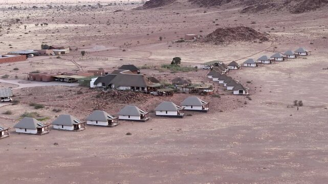 Aerial view of a desert lodge surrounded by vast arid plains near the Namib-Naukluft National Park in Namibia.