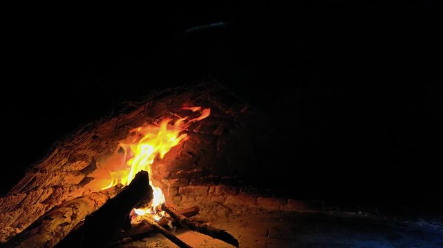 burning wood fire inside traditional brick oven in restaurant kitchen