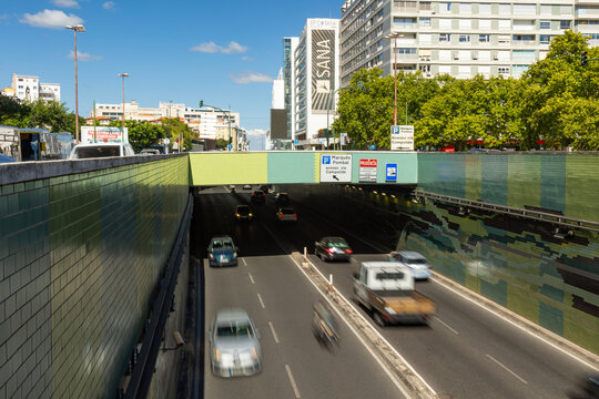 2026-07-16 Lisbon, Portugal - Busy urban road entering an underpass with motion blurred traffic in Lisbon, Portugal. Modern city transportation infrastructure featuring a road tunnel, moving vehicles 
