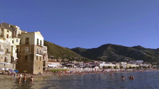 Crowded Beach and Historic Buildings in Cefalu Sicily During Summer