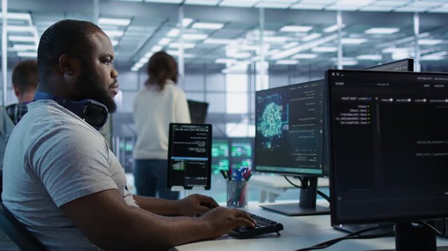 Happy engineer laughing at coworker joke while operating in high tech AI facility from a secondary camera angle as connecting protected data, access control and server room reliability.