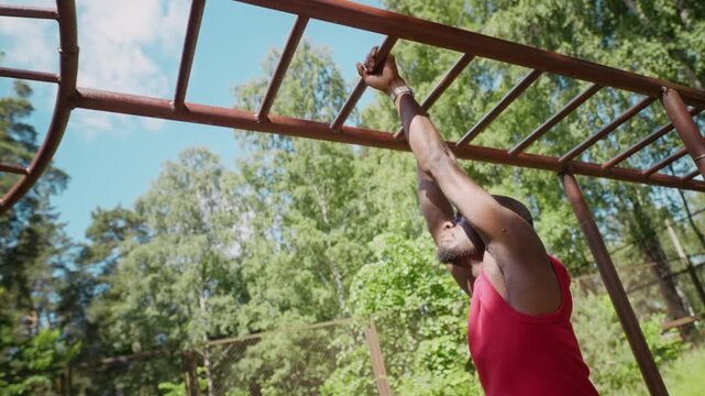 African American young adult man exercising on monkey bars at outdoor sports ground. Clip is perfect for promoting fitness, healthy lifestyle, and athletic training