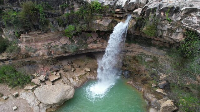 Tripod aerial footage of Salto de La Portellada waterfall on cloudy spring day. Teruel, Aragon, Spain.