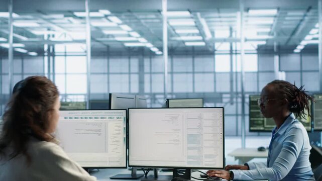 Admin arriving in server hub sitting at computer desk while data center, server hub and energy consumption support the task, captured with primary camera angle.