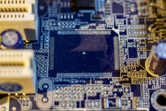 Macro view of electronic circuit board with microchip and various components in blue tones