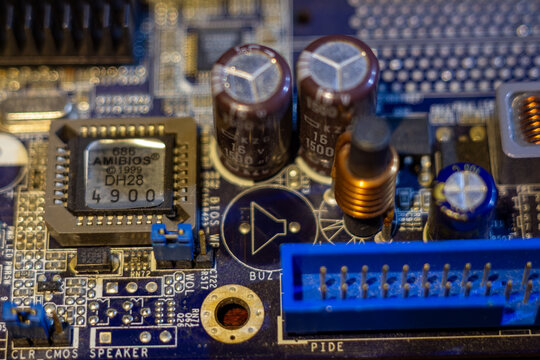 Motherboard computer hardware with bios chip and electrolytic capacitors on blue printed circuit board