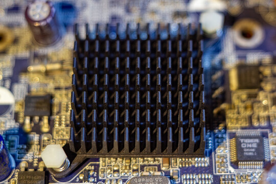 Black metal heatsink on computer motherboard with electronic components and microchips