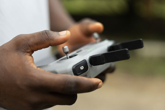 Hands operating the remote of a drone device