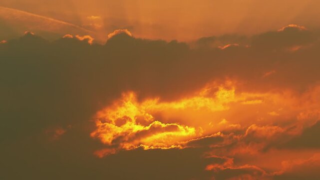 Dramatic time-lapse sunrise with bright sun rising above moving clouds, golden morning sky background, inspirational dawn landscape